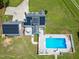 Aerial view of a house with solar panels and an in-ground pool with a diving board surrounded by a concrete patio at 2709 Les Paul Ln, Apex, NC 27539