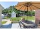 Backyard features patio seating area with shade umbrella, large grass area, shed, and white fence at 2709 Les Paul Ln, Apex, NC 27539
