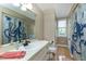 This bathroom features octopus shower curtains, wood floors, a white sink, and a window at 2709 Les Paul Ln, Apex, NC 27539