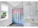 Neutral bathroom features colorful shower curtain and window with natural light at 2709 Les Paul Ln, Apex, NC 27539
