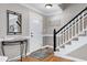 Inviting entryway featuring hardwood floors, staircase, and decorative mirror at 2709 Les Paul Ln, Apex, NC 27539