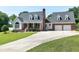 Inviting exterior of a two-story home featuring a brick facade, dormer windows, and a well-maintained front lawn at 2709 Les Paul Ln, Apex, NC 27539
