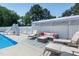 Inviting poolside lounge area with comfortable seating under a sunshade, adjacent to a refreshing pool and slide at 2709 Les Paul Ln, Apex, NC 27539