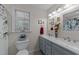 Bathroom with double sinks, soft grey cabinets and a large window for natural light at 2901 Ceremonial Ct, Raleigh, NC 27615
