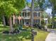 Brick two-story home with manicured lawn, mature trees, and a mailbox by the sidewalk at 2901 Ceremonial Ct, Raleigh, NC 27615