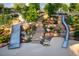 Playground with a metal slide and stone steps surrounded by green trees and landscaping at 3104 Kempthorne Rd # 48, Cary, NC 27519