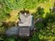 Stunning aerial view of home, showcasing mature trees, patio area with fire pit, and detached garage at 3137 Falling Cedars Dr, Chapel Hill, NC 27516