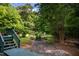 The backyard shows lush greenery, a stone patio, and an inviting outdoor seating area at 3137 Falling Cedars Dr, Chapel Hill, NC 27516