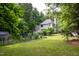 A lush backyard showing a well-maintained lawn, mature trees, and the home's back facade at 3137 Falling Cedars Dr, Chapel Hill, NC 27516
