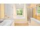 Bright bathroom featuring a bathtub, a shower, and a large window at 3137 Falling Cedars Dr, Chapel Hill, NC 27516
