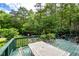An eye-level view of a backyard deck with a dining table and lush green landscaping at 3137 Falling Cedars Dr, Chapel Hill, NC 27516