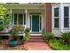 Close-up of front entrance with brick steps, potted plants, and a green front door at 3137 Falling Cedars Dr, Chapel Hill, NC 27516