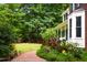 Manicured landscaping and brick walkway next to a brick home with a quaint front porch at 3137 Falling Cedars Dr, Chapel Hill, NC 27516