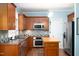 Modern kitchen featuring stainless steel appliances, tiled backsplash, and wood cabinets at 3137 Falling Cedars Dr, Chapel Hill, NC 27516