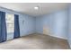 This bedroom features plush carpeting, a window with flowing curtains, and light blue painted walls at , Raleigh, NC 27610