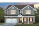 Charming two-story home with gray siding, brick accents, covered porch, and attached two-car garage at 344 Bridle Brook Way, Fuquay Varina, NC 27526
