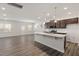 Kitchen with an island, stainless steel appliances, granite countertops, dark wood cabinets, and wood flooring at 344 Bridle Brook Way, Fuquay Varina, NC 27526