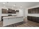Kitchen with an island, stainless steel appliances, granite countertops, dark wood cabinets, and wood flooring at 344 Bridle Brook Way, Fuquay Varina, NC 27526