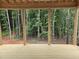 View from the new wooden porch, with exposed beam framework, into the lush greenery of the forest at 3905 Cedar Knolls Dr, Youngsville, NC 27596