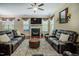 Spacious living room showcasing fireplace, large screen tv, ceiling fan, and plush leather seating at 413 Barnard Castle Ct, Rolesville, NC 27571