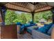 Covered outdoor lounge with stylish wicker furniture, grill, and backyard views at 413 Barnard Castle Ct, Rolesville, NC 27571