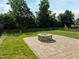Landscaped backyard featuring a stone fire pit and lush green lawn at 418 Wyndham Drive, Chapel Hill, NC 27516