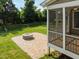 Inviting backyard featuring a patio with a fire pit, screened porch, and black metal fencing at 418 Wyndham Drive, Chapel Hill, NC 27516