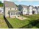 Backyard view of a home with a screened porch, patio with a fire pit, and black metal fencing at 418 Wyndham Drive, Chapel Hill, NC 27516