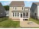Back exterior featuring a screened-in porch, patio with firepit, and manicured lawn at 418 Wyndham Drive, Chapel Hill, NC 27516