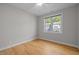 Vacant bedroom with light gray walls, hardwood floors and large window overlooking the neighborhood at 418 Wyndham Drive, Chapel Hill, NC 27516