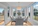 Sunlit dining area featuring a round table, elegant chairs, and large windows offering outdoor views at 418 Wyndham Drive, Chapel Hill, NC 27516