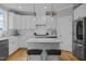 Modern kitchen featuring white cabinets, stainless steel appliances, and an island with barstool seating at 418 Wyndham Drive, Chapel Hill, NC 27516