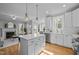 Bright kitchen featuring white cabinets, stainless steel appliances, and an island with pendant lighting at 418 Wyndham Drive, Chapel Hill, NC 27516