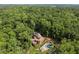 Aerial view of the home nestled within a vast forest, with a pool and landscaped grounds at 4312 Mystic Ln, Hillsborough, NC 27278