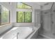 Bathroom features a soaking tub, walk-in shower and view to the outside at 4312 Mystic Ln, Hillsborough, NC 27278