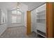 Bright bedroom featuring a ceiling fan, built-in closet organizer, and natural light through the shuttered windows at 4312 Mystic Ln, Hillsborough, NC 27278