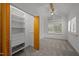 Bright bedroom featuring a ceiling fan, built-in closet organizer, and natural light through the shuttered windows at 4312 Mystic Ln, Hillsborough, NC 27278