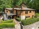 A charming multi-story home with a spacious deck, stairs, stone wall, and lush landscaping at 4312 Mystic Ln, Hillsborough, NC 27278