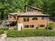 A charming multi-story home with a deck, stairs, a stone wall, surrounded by mature trees at 4312 Mystic Ln, Hillsborough, NC 27278