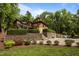 Beautiful two-story home with lush landscaping and stone retaining walls, overlooking a pool area at 4312 Mystic Ln, Hillsborough, NC 27278