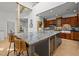 Kitchen island featuring stone countertops, wooden cabinets, bar seating, and hardwood floors at 4312 Mystic Ln, Hillsborough, NC 27278