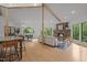 Open-concept living room with wood floors, stone fireplace, and large windows offering natural light at 4312 Mystic Ln, Hillsborough, NC 27278