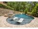 Relaxing pool area features in-pool lounge chairs, a hot tub, and a waterfall feature at 4312 Mystic Ln, Hillsborough, NC 27278