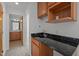 Wet bar featuring upper and lower maple cabinets, granite countertops and stainless sink at 4312 Mystic Ln, Hillsborough, NC 27278