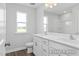 Bathroom with double vanity, and wood-look floors, illuminated by natural light from a large window at 444 Golden Dragonfly St, Wake Forest, NC 27587