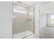 Close-up of shower with glass door, tiled walls, and a window at 444 Golden Dragonfly St, Wake Forest, NC 27587