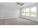 Bedroom with carpet flooring, ceiling fan, and large windows offering natural light and backyard views at 444 Golden Dragonfly St, Wake Forest, NC 27587