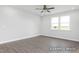 A bright bedroom featuring gray wood flooring, a ceiling fan, natural light, and views to the outside at 444 Golden Dragonfly St, Wake Forest, NC 27587