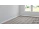 Bedroom with neutral walls, carpet floors, and natural light from large windows overlooking green space at 444 Golden Dragonfly St, Wake Forest, NC 27587