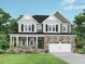 Charming two-story home with stone accents, covered porch, and lush green lawn at 444 Golden Dragonfly St, Wake Forest, NC 27587